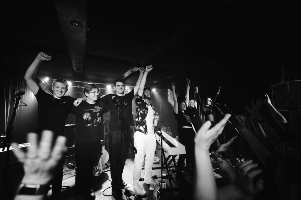 Group photo of Billy Lockett and his band standing on stage, taken by a local photographer